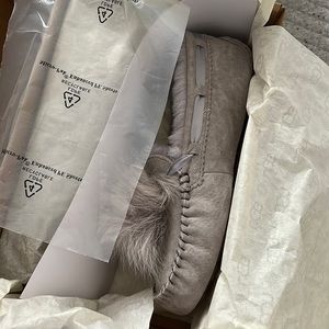 UGG Dakota PomPom moccasin in gray.  New in box.  Never worn.